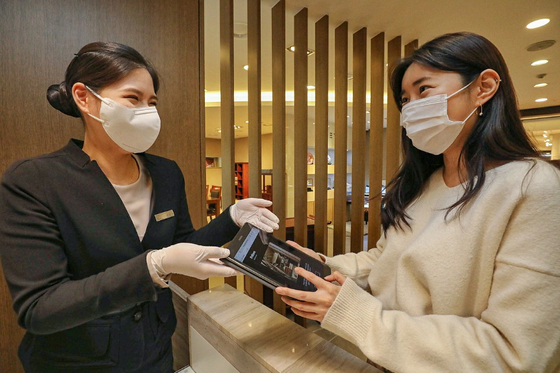 A Hyundai Department Store employee explains about Club YP to a customer at its trade center branch in southern Seoul. [HYUNDAI DEPARTMENT STORE] 