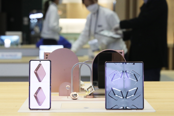 Visitors take a look at mobile phones at a booth set up by Samsung Electronics as part of the 2020 Korea Electronics Show held Wednesday at Coex in southern Seoul. The event, held jointly with the Grand Electronics Fair 2020, will run through Saturday. [YONHAP]