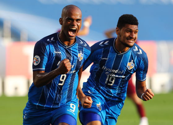 Junior Negao, left, celebrates with Bjorn Johnsen after scoring the winning goal for Ulsan Hyundai FC against Vissel Kobe in the AFC Champions League semifinal in Qatar on Sunday. [REUTERS/YONHAP]