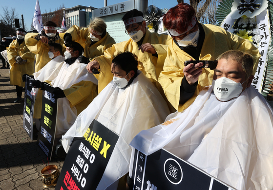 Gym owners and representatives of an association of local fitness center proprietors protest the government’s shutdown orders Wednesday during a press conference in Yeouido, western Seoul, as some shave their heads. Indoor gyms have been forced to close in Level 2.5 social distancing measures. [YONHAP]