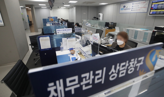 A Shinhan Bank employee works at a branch in Seoul on Wednesday. According to the bank, it has temporarily stopped accepting most loan applications from customers amid concern about rapidly increasing household debt. It is expected that it will begin processing applications again from Jan. 4. [YONHAP]