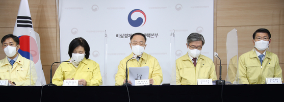 Finance Minister Hong Nam-ki, center, with other top government officials including Financial Services Commission Chairman Eun sung-soo, far right, at a press briefing held at the government complex in Seoul on Tuesday. [YONHAP]
