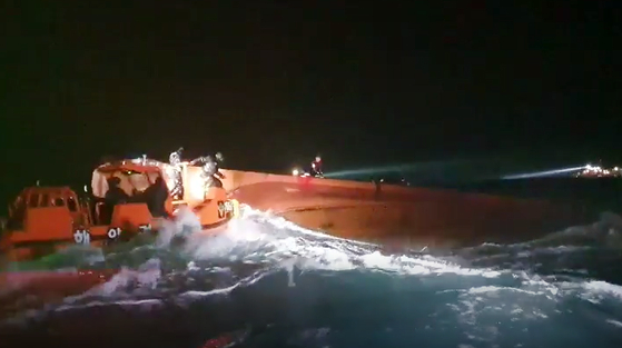 Marine police attempt to rescue seven fishermen after their boat capsized in the waters off Jeju Island on Tuesday night. None of the fishermen have been rescued as of noon Wednesday. [NEWS1]