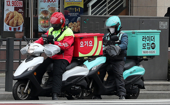 Baedal Minjok and Yogiyo riders are seen working in Jongno, central Seoul on Dec. 29. [NEWS1]