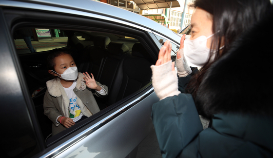 A first grader at Jeongpyeong Elementary School in Gyeongsan, North Gyeongsang, meets her teacher for the first time Monday during a drive-thru orientation organized by the school to prevent the spread of the coronavirus. [YONHAP] 
