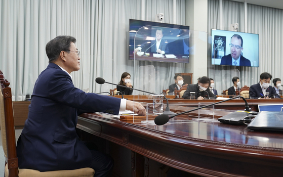 President Moon Jae-in, left, participates in a videoconference with Moderna CEO Stéphane Bancel on Monday at the Blue House. [YONHAP]