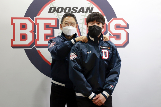 Kim Jae-ho, right, takes a commemorative photo after re-signing with the Doosan Bears on Friday. [YONHAP]