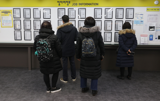People looking at a job bulletin board at a job center in Mapo, Seoul on Jan. 13. Due to Covid-19 job losses last year amounted to its largest since IMF crisis. [YONHAP]