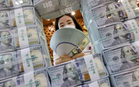 An employee of Hana Bank organizes dollars at its headquarters in Jung District, central Seoul, on Wednesday. [YONHAP]