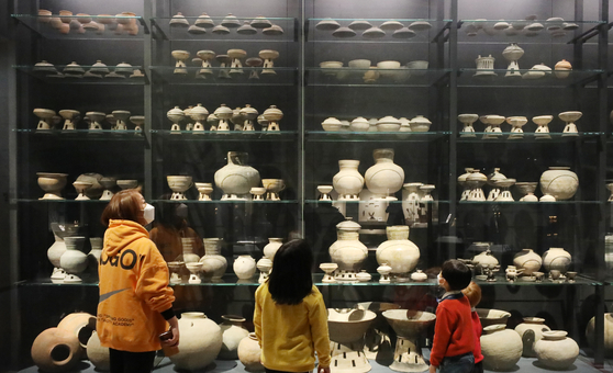 Visitors look at artifacts on display at the National Museum of Korea in Yongsan District, central Seoul, on Tuesday. Major state-run museums and theaters in Seoul reopened on Tuesday after being closed for six weeks due to the surge in coronavirus cases.  [NEWS1]