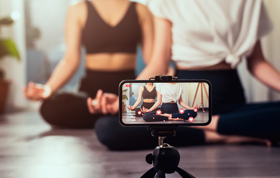 Yoga classes streamed online via a smartphone. [SHUTTERSTOCK]