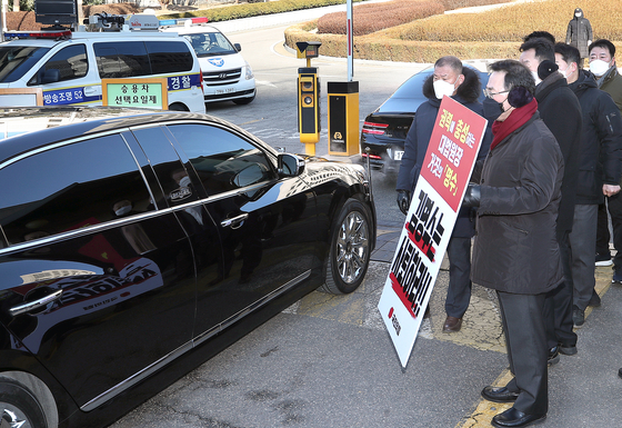 Floor leader Joo Ho-young of the People Power Party holds a sign demanding the resignation of Chief Justice Kim at the entrance of the Supreme Court as the justice's car enters the compound. [YONHAP]