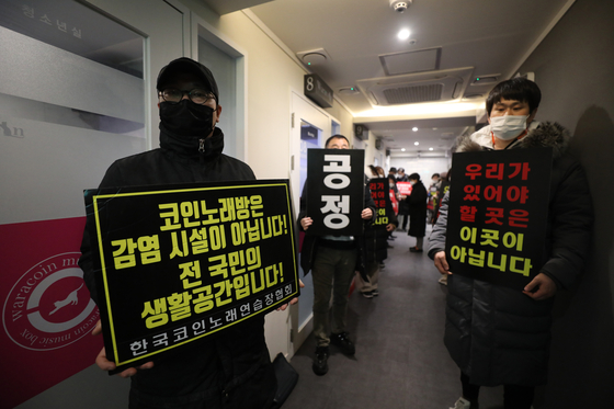 Coin noraebang owners demonstrates against the government business hours restriction at a coin noraebang in Seodaemnu, Seoul on Tuesday. [NEWS1]