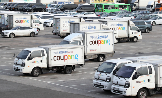 Coupang delivery trucks parked in a lot in Seocho District, southern Seoul, on Tuesday. The company disclosed on Tuesday its plans for distributing to a group of employees shares worth around 2 million won per person. [YONHAP]