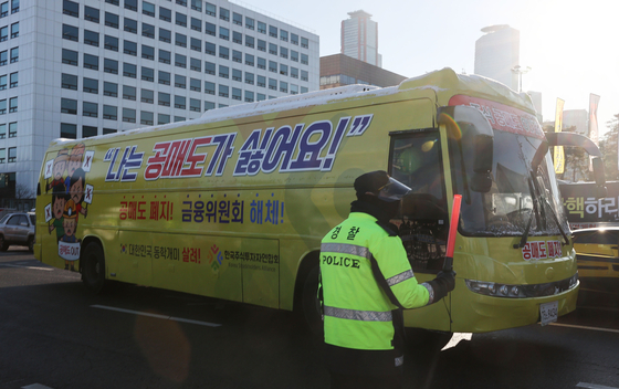 A bus decorated with signs supporting the short selling ban operated by the Korea Stockholders Alliance, a group of local retail investors, passes by the National Assembly building in Yeouido, western Seoul, on Thursday. [YONHAP]
