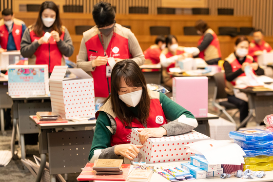 Lotte World employees wrap gifts for underprivileged young people ahead of the Lunar New Year holiday. [LOTTE GROUP]
