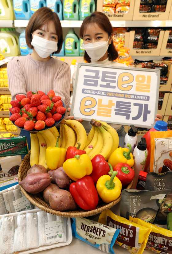Models pose with various fruits at Emart's Seongsu branch in eastern Seoul on Thursday. According to the retailer, Emart is running an event on Friday and Saturday to offer fresh food and daily necessities at sharply discounted prices. [YONHAP] 