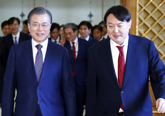 In this file photo, President Moon Jae-in, left, and Prosecutor General Yoon Seok-youl head toward a reception after Moon formally appoints Yoon as the top prosecutor on July 25, 2019.  [YONHAP] 