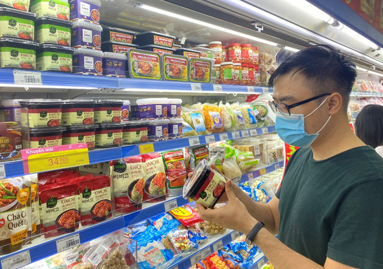 A customer looks at kimchi at a shop in Vietnam. According to CJ CheilJedang on Monday, sales of Bibigo kimchi in Vietnam posted 15 billion won ($13.2 million) last year, up 25 percent on year. [YONHAP] 
