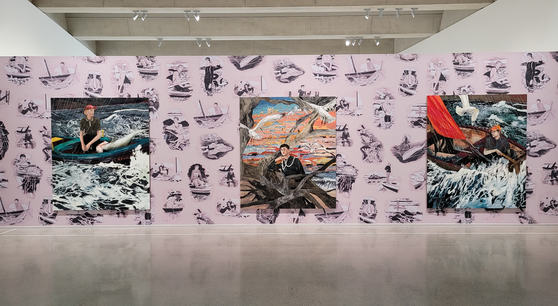  Large-scale paintings by American artist Hernan Bas including “The Young Man and the Sea,” left, are hanging on a wall covered with wallpaper, which is the artist’s work “Monsters and Mariners.” They are part of a solo show of Bas, which started last month at Space K Seoul, a new museum that Kolon Group opened last autumn in Magok, a far western area of Seoul. [MOON SO-YOUNG]