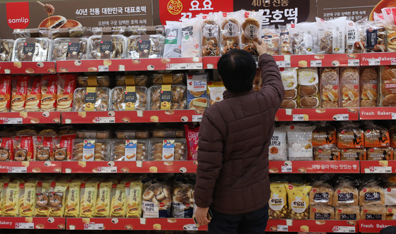 A customer looks at sweet bread on a shelf at a big discount store in downtown Seoul on Wednesday. With the price of grain sharply increasing across the globe, SPC Samlip said it will increase the prices of some 20 bakery products by around 9 percent starting from Friday. [NEWS1]