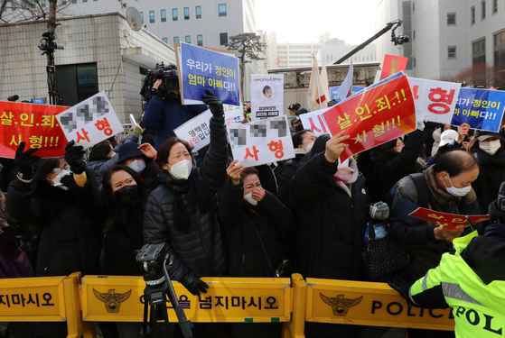 People hold up signs calling for a death sentence for the adoptive parents of a 16-month-old, who died after being brutally abused, at the Seoul Southern District Court on Wednesday, the first day of the trial of the adoptive parents. [NEWS1]