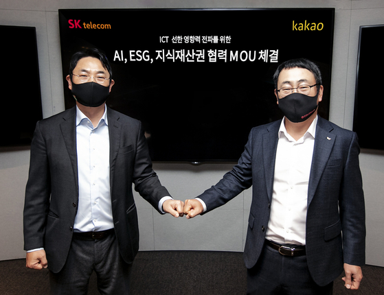 Yeo Min-soo, Co-CEO of Kakao, left, and Ryu Young-sang, head of the mobile network operations division of SK Telecom, exchange a fist bump after signing a memorandum of understanding to collaborate on developing artificial intelligence (AI) technology, creating environmental, social and governance (ESG) funds and sharing intellectual property rights as part of efforts to contribute to society at Kakao's office in Pangyo, Gyeonggi. [KAKAO] 