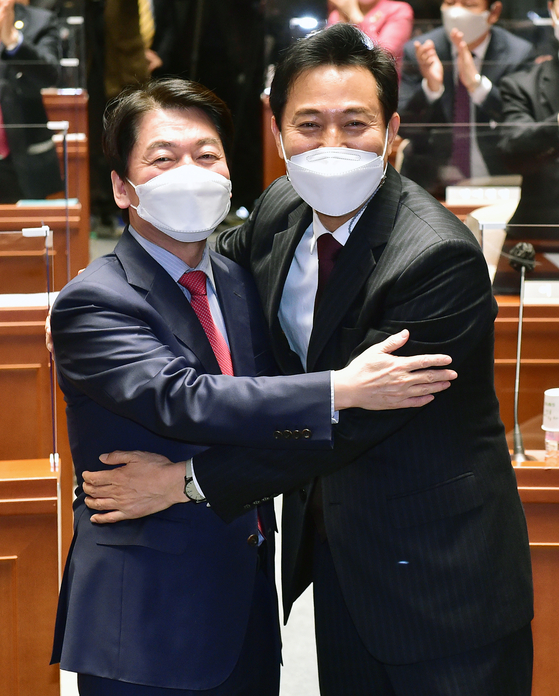 Ahn Cheol-soo, left, chairman of the People’s Party, embraces Oh Se-hoon, who won the ticket of the opposition bloc to run in the Seoul mayoral by-election, at a party lawmakers’ meeting in the National Assembly in Yeouido, western Seoul, on Wednesday. Ahn accepted co-chairmanship of the campaign for Oh, who beat Ahn in the preliminary opinion polls. [OH JONG-TAEK]