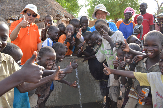 Volunteers from the Korea International Cooperation Agency (Koica) and local residents rejoice after tap water flows in a development project for a village in Senegal in 2013. [KOICA]