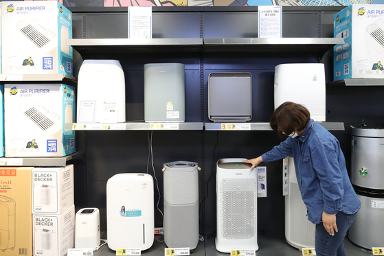 A customer shops for an air purifier at a big retailer in downtown Seoul as an extraordinarily severe yellow dust storm from northern China and Mongolia blanketed Korea on Monday. [YONHAP]