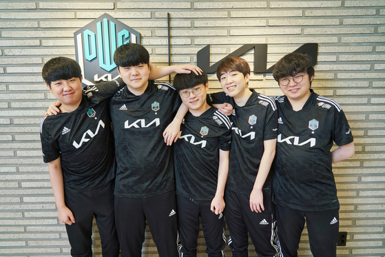 The DWG KIA League of Legends team pose for the camera in the media room of their new headquarters. [DWG KIA]