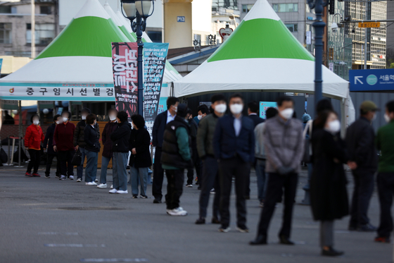 People line up to get tested for Covid-19 at Seoul Station Square on Monday. [NEWS 1]