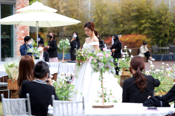 A model poses at a wedding demonstration in the outdoor roof garden of Lotte Department Store's Daegu branch, in Buk District, Daegu. According to Lotte Department Store, small weddings are becoming popular amid the Covid-19 pandemic.[YONHAP]