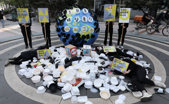 Environmental activists on Tuesday hold a press conference in front of the headquarters of Baedal Minjok, also known as Baemin, the largest food delivery app operator in Korea, urging food delivery apps to use less disposable containers. [NEWS1]