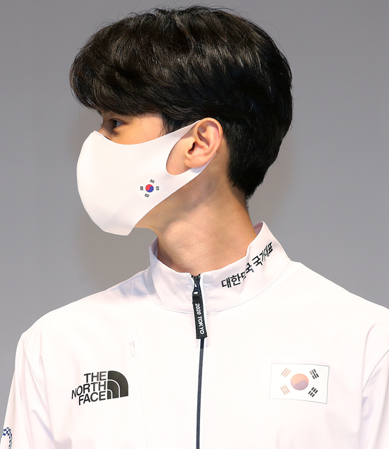 An athlete poses in Team Korea's 2020 Tokyo Olympics uniform, including a team mask. [NEWS1]