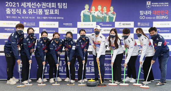 From left: Curling Coach Kim Myung-seop, 2018 Pyeongchang Olympics silver medalists Team Kim -- Kim Cho-hee, Kim Kyung-ae, Kim Young-mi, Kim Sun-young and Kim Eun-jung -- Chairman of the Korea Curling Association Kim Yong-bin, mixed doubles team Kim Ji-yoon, Moon Si-woo and Lee Hye-in and Gangwon Curling Federation Chairman Chung Eui-jung pose after unveiling the national team uniforms at T Tower in Jung District, central Seoul. The two teams will compete at the upcoming curling world championships to earn a spot at the 2022 Beijing Olympics. [YONHAP]