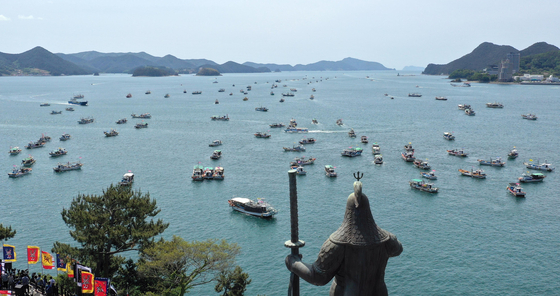 Fishing boats in the sea off Tongyeong, South Gyeongsang, on Monday protest Japan’s decision to dump contaminated water into the Pacific Ocean. The statue of Admiral Yi Sun-shin, a national hero who beat invading Japanese war ships in 1592, looks over the sea. [YONHAP]