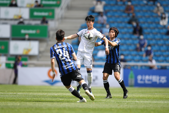 Kim Ji-hyun of Ulsan Hyundai Motors, center, traps the ball in a game against Incheon United at Incheon Football Stadium in Incheon on Sunday.  [KLEAGUE]