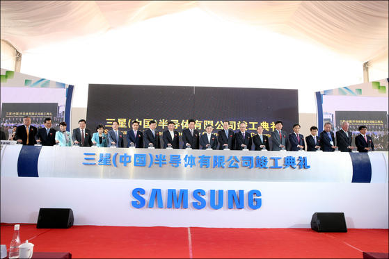 Representatives at Samsung Electronics and Chinese government officials celebrate the operation of a chip plant in 2014. [SAMSUNG ELECTRONICS]
