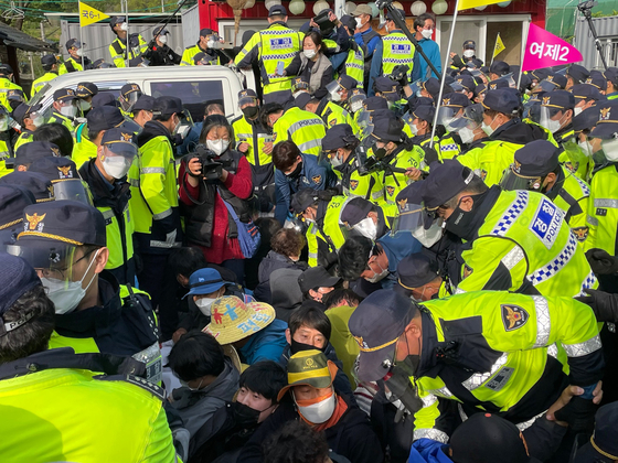 Police troops remove protesters on the road heading to the U.S. Forces Korea's Terminal High Altitude Area Defense base in Seongju, North Gyeongsang, on Wednesday. [YONHAP]