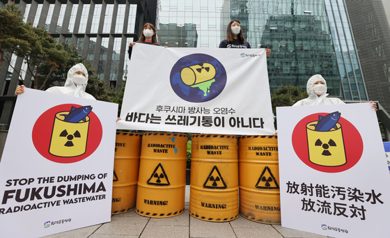 Members of the Korea Federation for Environmental Movements protest the Japanese government's decision to release contaminated water from its Fukushima nuclear power plant in front of the the Japanese Embassy in central Seoul on Wednesday. The banner says, the "ocean is not a trash can." [YONHAP]