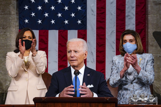 U.S. President Joe Biden, center, makes his first formal address to a joint session of Congress Wednesday in Washington, with Vice President Kamala Harris and House Speaker Nancy Pelosi applauding behind him. [AP/YONHAP]