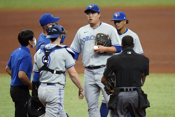 Toronto Blue Jays starting pitcher Ryu Hyun-jin, center, reacts after getting hurt during the fourth inning of a baseball game against the Tampa Bay Rays on Sunday. [AP/YONHAP]
