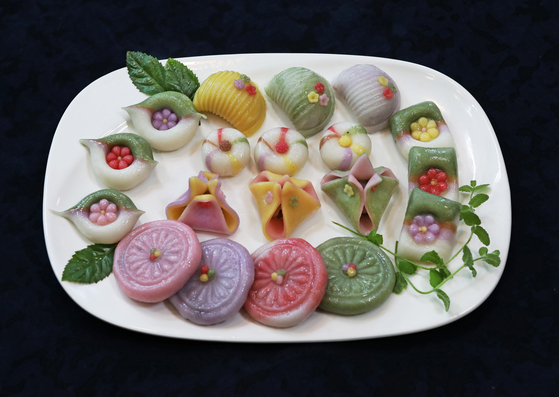 Kim's various flower-shaped tteok: ‘Baram-tteok’ (half-moon shaped rice cakes filled with bean paste), ‘kkot-sanbyeong’ (flower-patterned tteok) and ‘satang jeolpyeon’ (candied tteok). [PARK SANG-MOON]