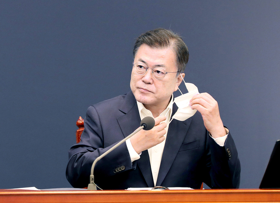  President Moon Jae-in takes off his mask to address a meeting about the government’s public health measures against the pandemic Monday in the Blue House.