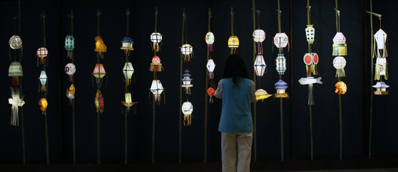 A visitor admires different lanterns on display at the "Yeondeunghoe: Lighting up the mind and the world" exhibit at the Central Buddhist Museum in central Seoul. [NEWS1]