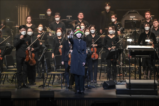 Conductor Chin Sol stands on the stage at the Sejong Center for the Performing Arts on April 9 after finishing the “League of Legends Live: The Orchestra” concert, wearing a hat of the popular character Teemo from the League of Legends video game. [SEJONG CENTER FOR THE PERFORMING ARTS]