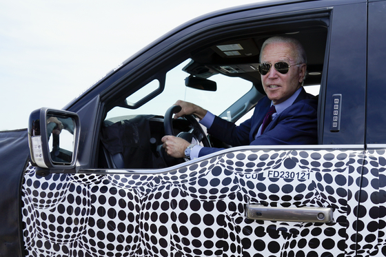 U.S. President Joe Biden stops to talk to the media as he drives a Ford F-150 Lightning truck at Ford Dearborn Development Center, Tuesday, May 18, 2021, in Dearborn, Michigan. [AP/YONHAP]