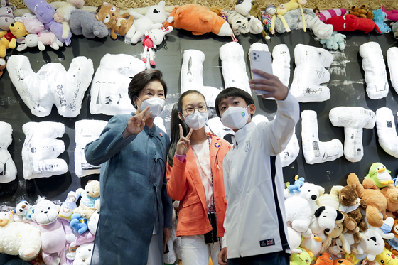 First Lady Kim Jung-sook, left, takes selfies with children at the “Tong’s Vintage: The Strange Tongui General Store” exhibition at the Daelim Museum in Tongui-dong, Jongno District, central Seoul, on Wednesday. The exhibition is designed to celebrate the 2021 Partnering for Green Growth and the Global Goals 2030 (P4G) Summit in Seoul, Korea’s first multilateral summit on environmental issues to be held on May 30 and 31. [NEWS1]