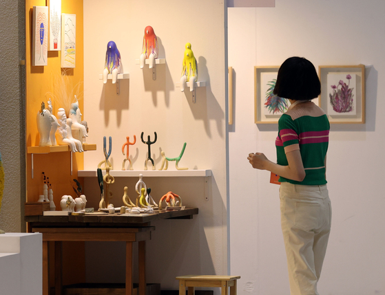 A visitor to Seoul Living Design Fair takes a look at small home décor items. The fair at Coex, southern Seoul's Gangnam District, lasts until Sunday. [YONHAP]